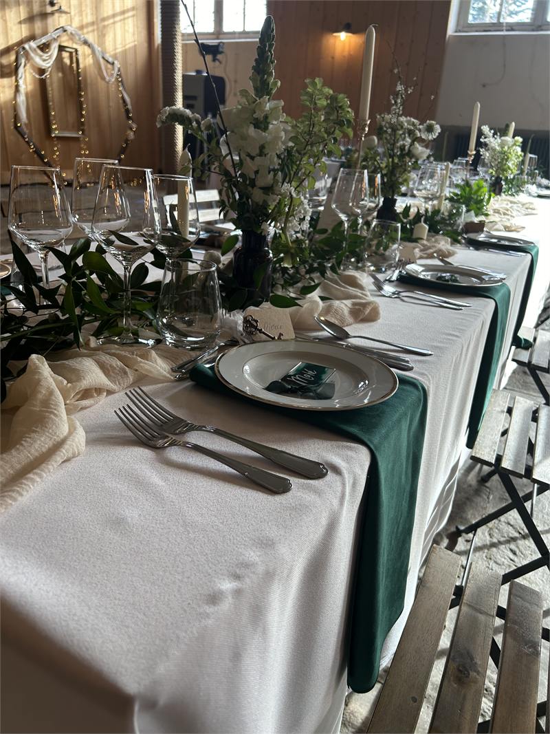 Table de réception dressée avec verdure de saison et nappage en tissu